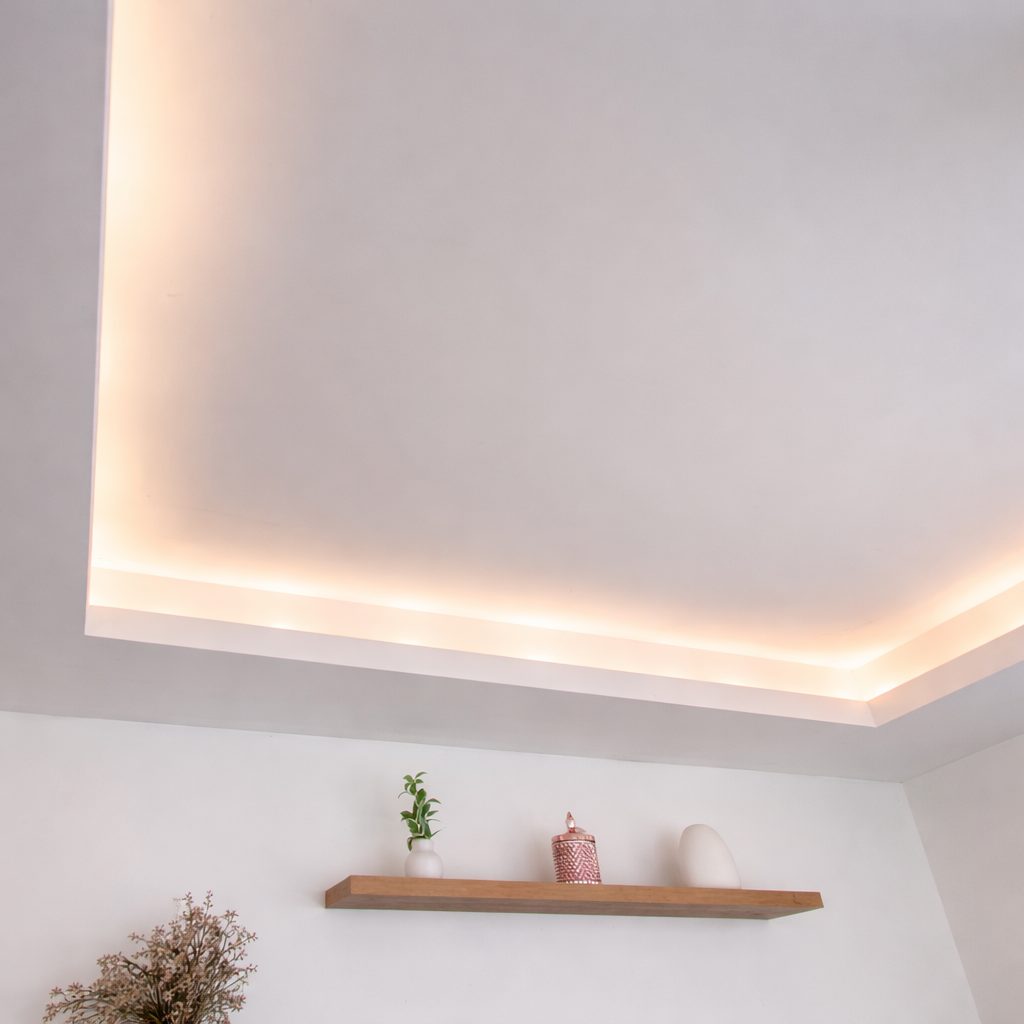 Clean dropped ceiling with perimeter cove detail in a modern bedroom